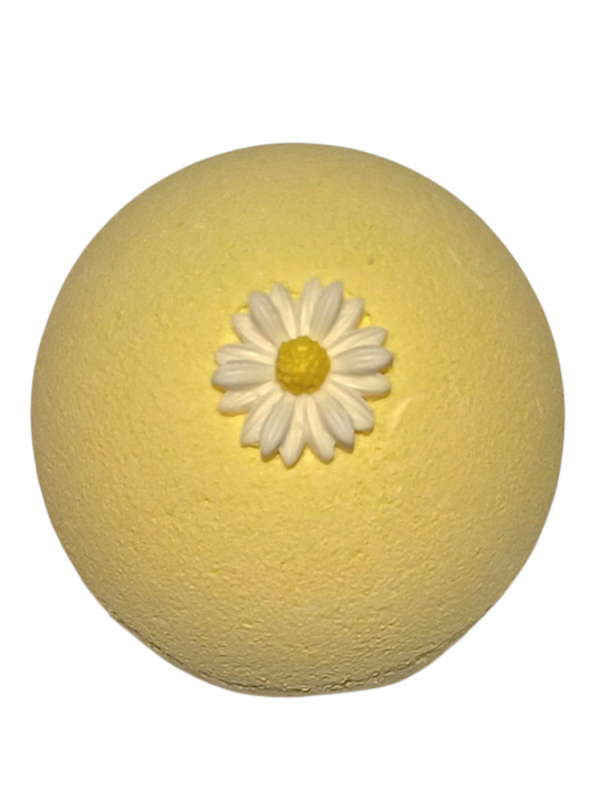 Yellow bath bomb with a white flower on top.