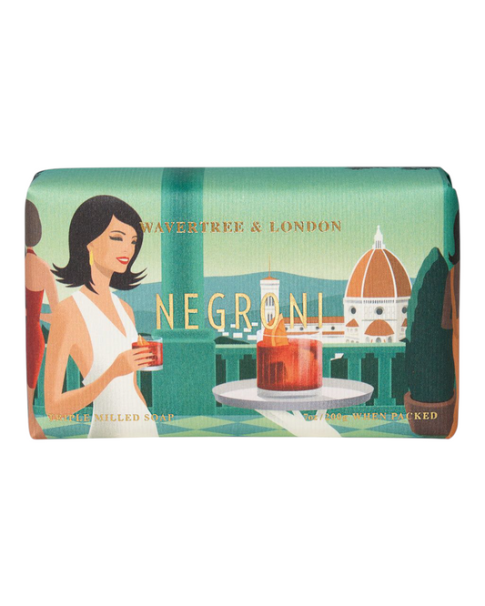 A bar of Wavertree & London soap with packaging featuring an illustration of a woman holding a Negroni cocktail, with the cityscape of Florence in the background.